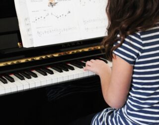 girl piano student practicing the piano