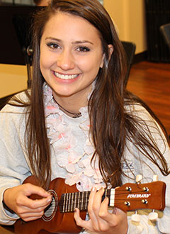 teenager plays the ukulele