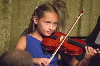 Violin student performing at recital