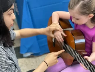 girl playing a guitar lesson